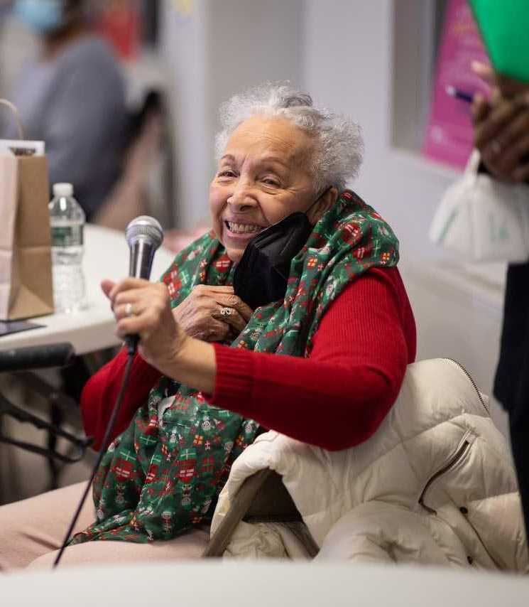 Older woman sitting in chair with a microphone